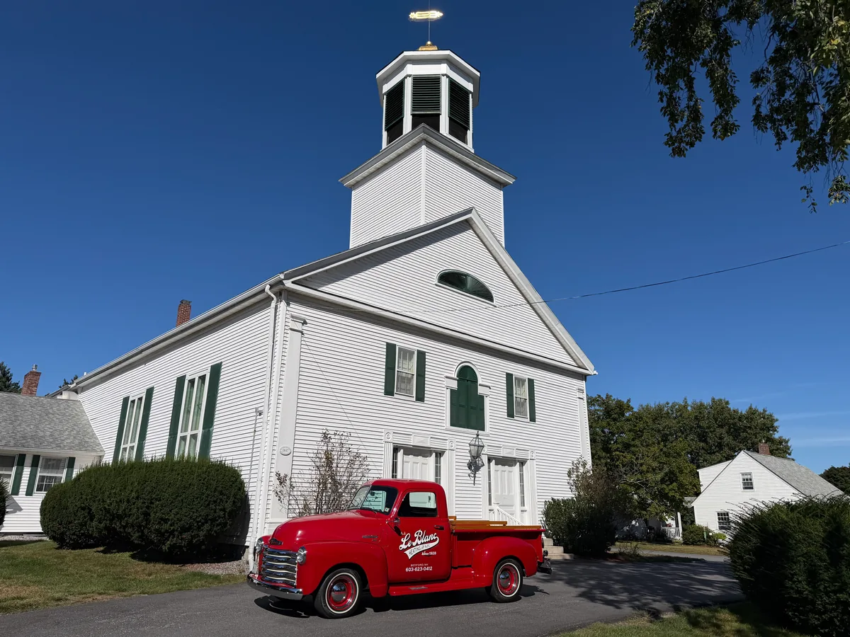 A.J. LeBlanc Heating red vintage truck outside First Church of Merrimack, New Hampshire