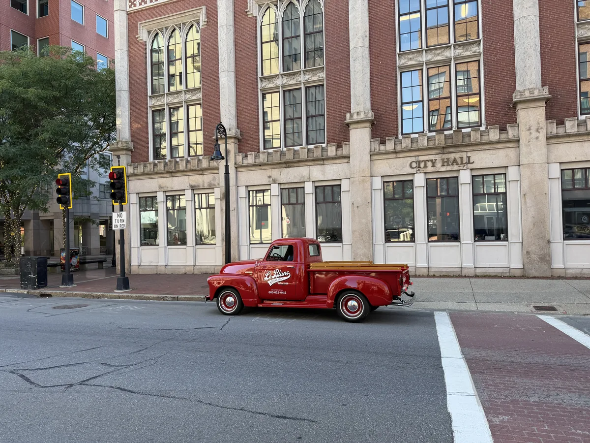 A.J. LeBlanc Heating red vintage truck outside Manchester City Hall, New Hampshire