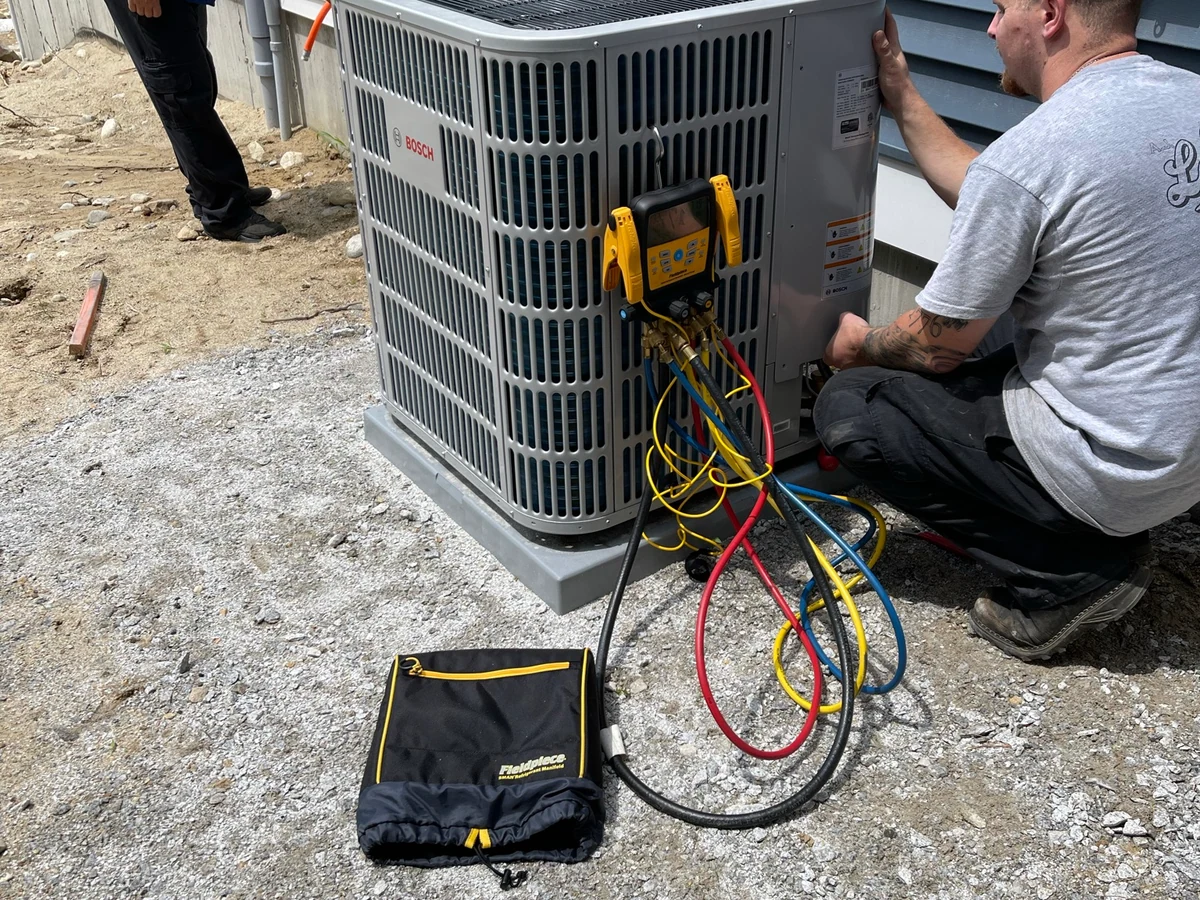 A.J. LeBlanc Heating technicians commissioning a Bosch outdoor condenser at a new construction home in Southern NH