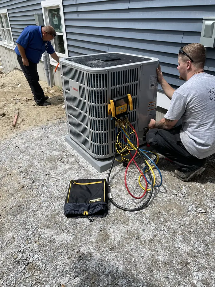 A.J. LeBlanc Heating technicians commissioning a Bosch outdoor condenser at a new construction home in Southern NH