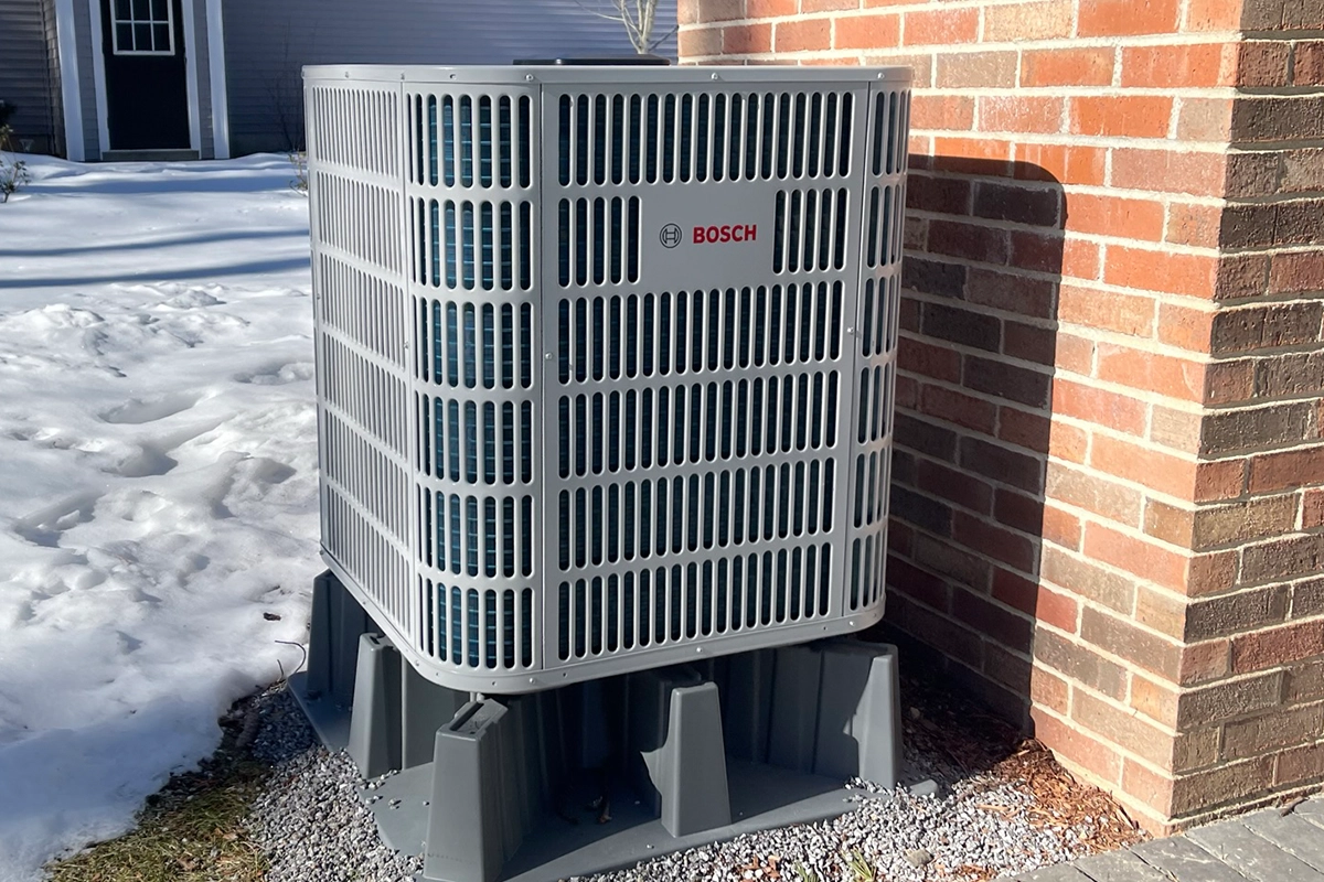 Cold-climate heat pump outdoor unit operating in New Hampshire winter conditions near Manchester NH