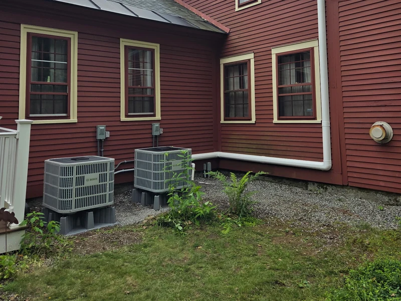 Two Bosch outdoor units beside a red-sided home