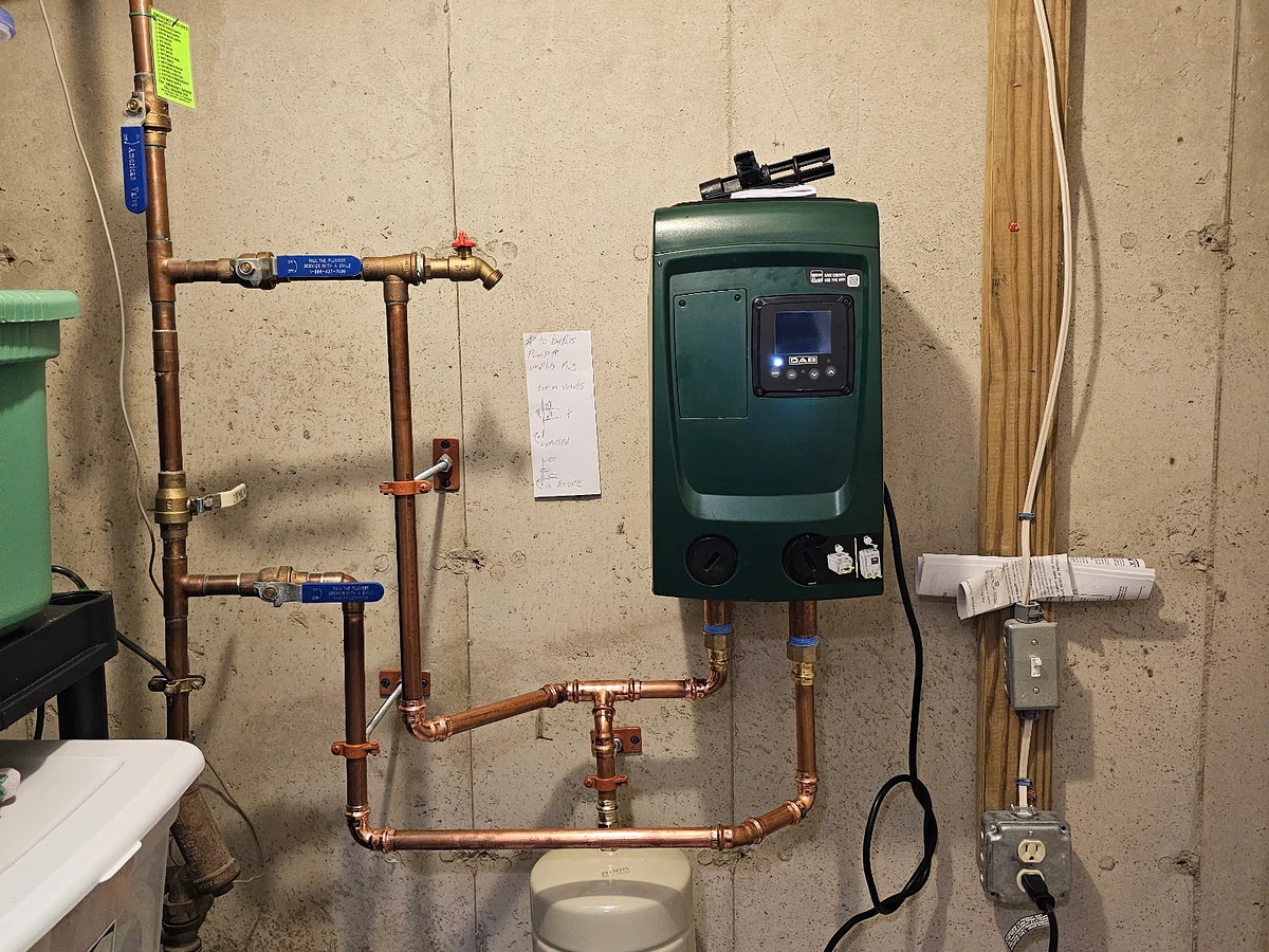 City water pressure booster pump with copper supply lines and expansion tank installed in a Southern NH mechanical room by A.J. LeBlanc Heating