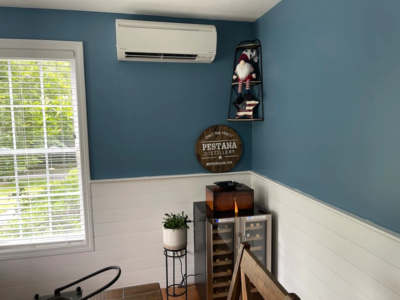 Daikin wall-mounted ductless mini split head installed on a teal accent wall in a Southern NH home