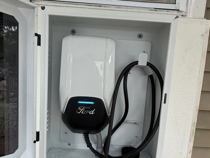 Ford home EV charger mounted inside a weatherproof outdoor enclosure, installed by A.J. LeBlanc Heating in Southern NH