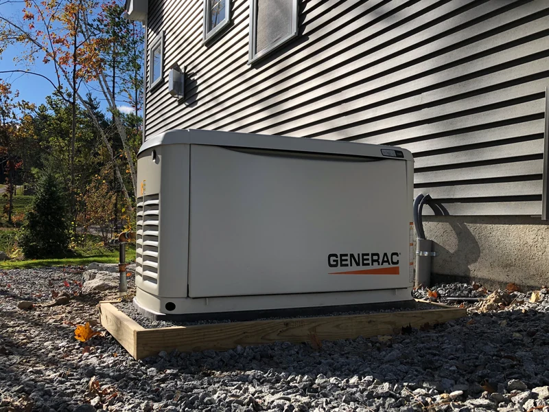 Generac home standby generator on a residential gravel pad as an alternative to battery backup, installed by A.J. LeBlanc Heating in Southern NH