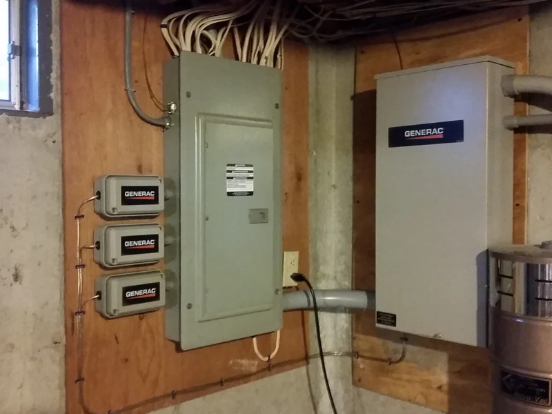 Interior basement install showing three Generac SmartSwitch load shedding modules wired alongside a Generac automatic transfer switch and main panel in a Southern NH home, by A.J. LeBlanc Heating