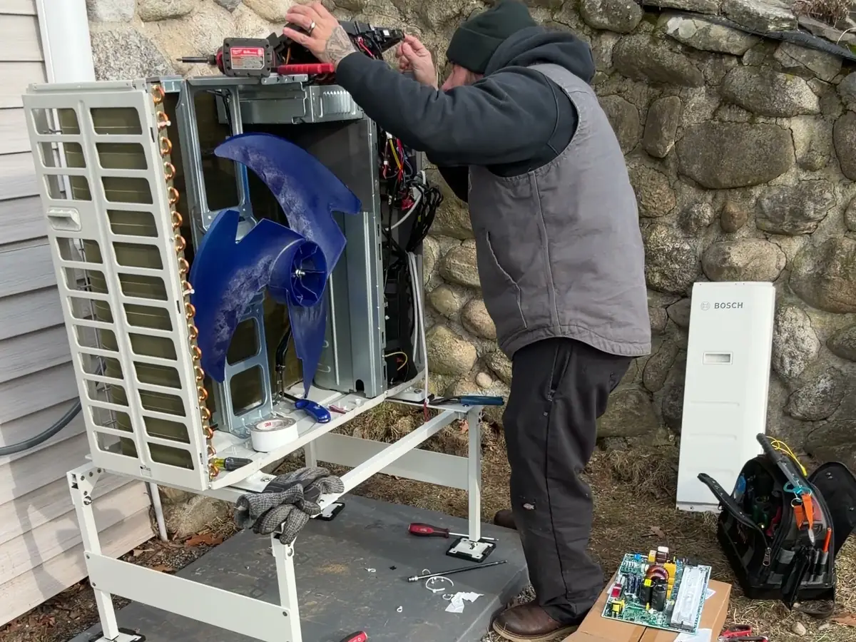 A.J. LeBlanc Heating technician repairing a ductless mini split outdoor unit and control board in Southern NH