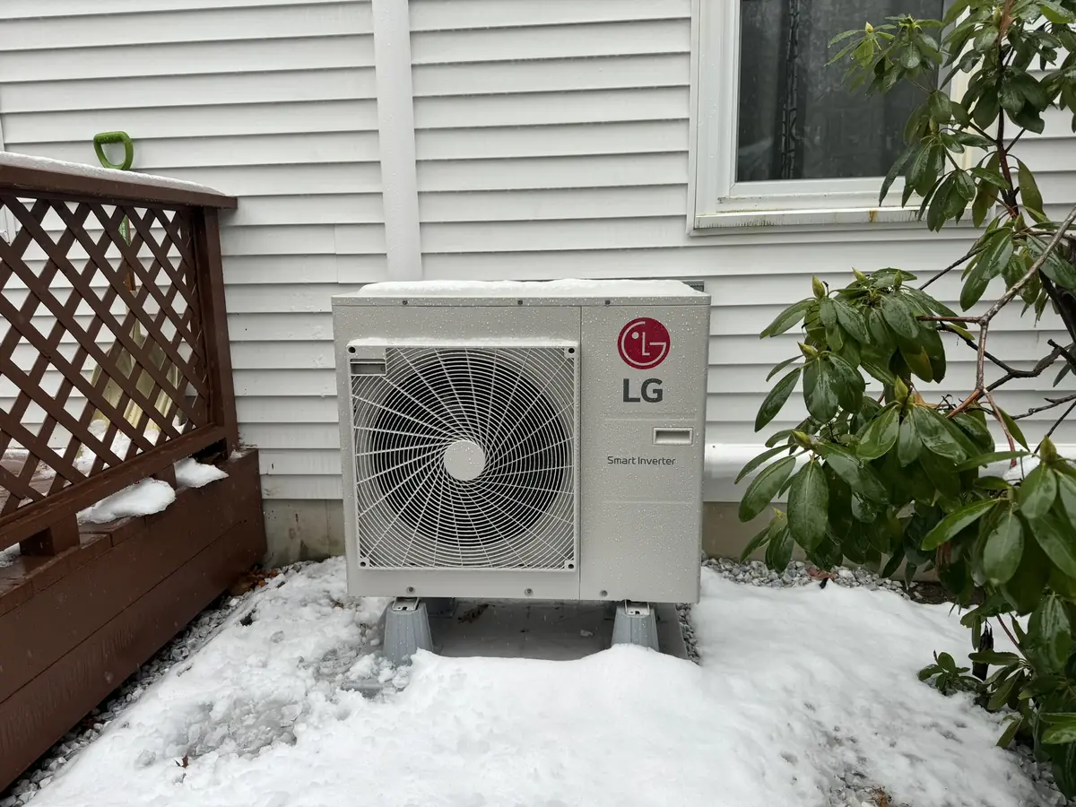 LG ductless mini split outdoor heat pump running through a Southern NH winter snowfall, installed by A.J. LeBlanc Heating