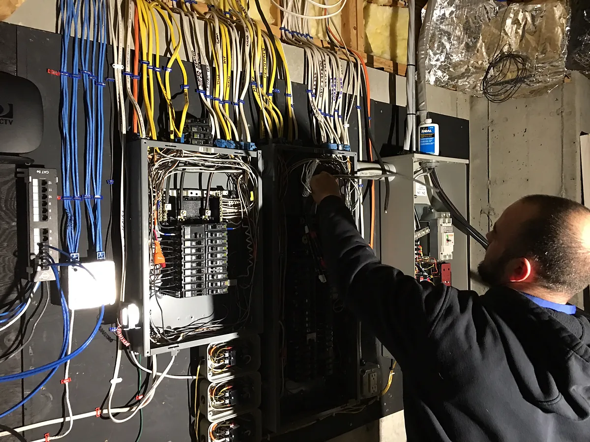 A.J. LeBlanc Heating licensed electrician wiring a 200-amp electrical panel in Southern NH