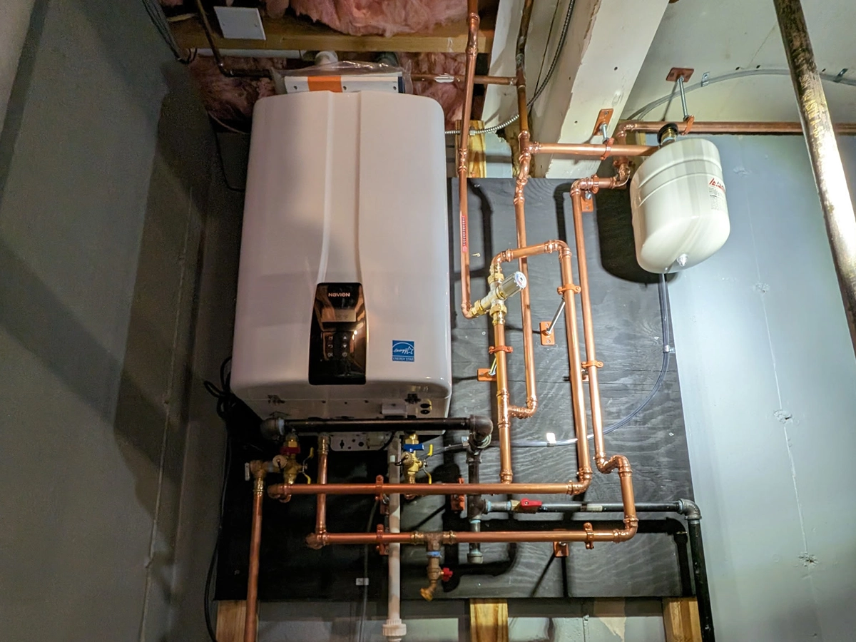 Navien on-demand tankless water heater serviced by A.J. LeBlanc Heating licensed plumbers in a Southern NH home