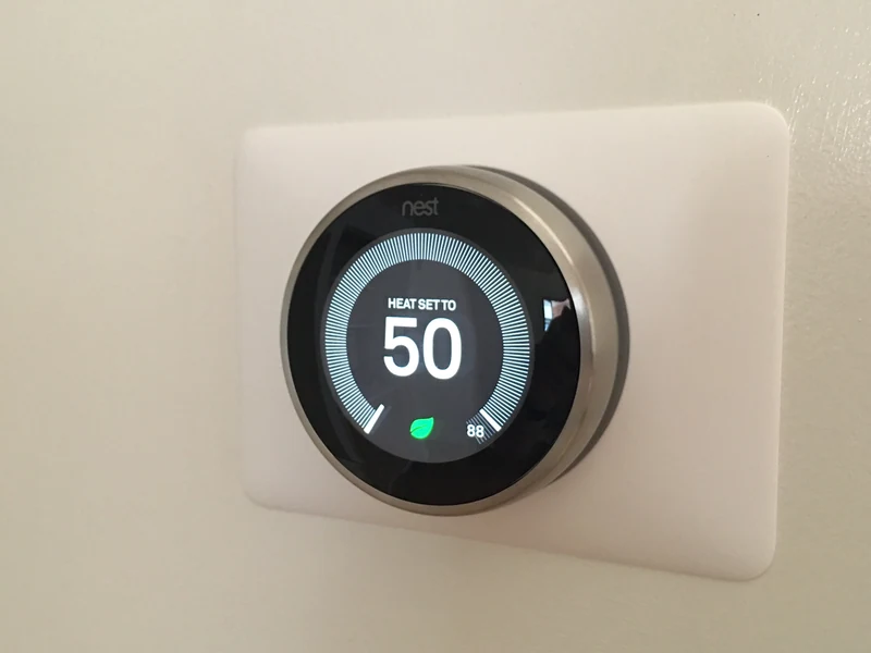 Google Nest smart thermostat with mounting plate installed by A.J. LeBlanc Heating in a Southern NH home