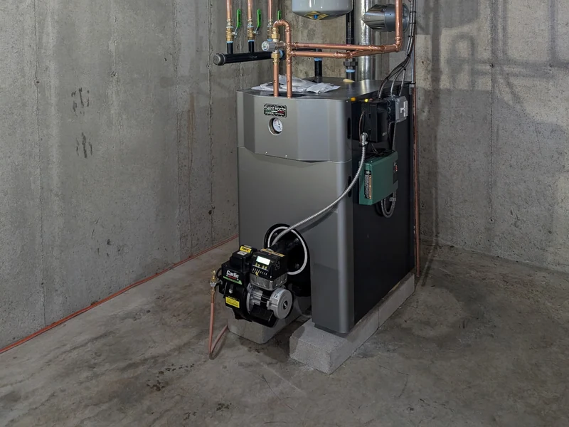 Saint Roch cast-iron oil boiler with Carlin burner and copper multi-zone manifold in a Southern NH basement
