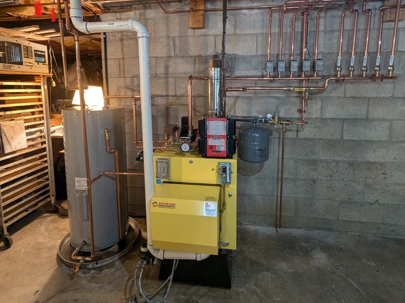 System 2000 boiler beside a water heater with overhead copper piping